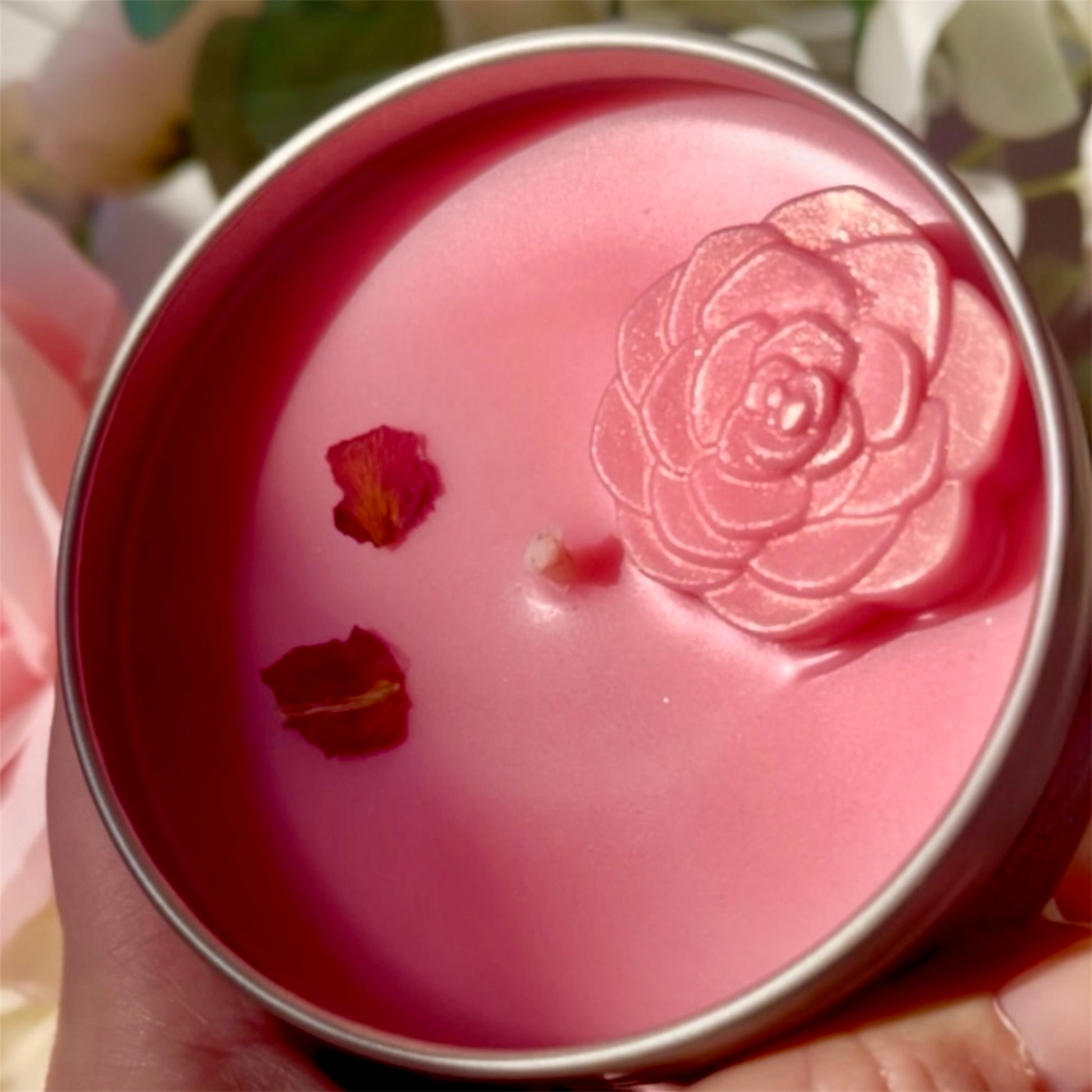 Hand-poured Blushing Rose Noir candle shown in hand, highlighting detailed rose wax embed and luxury finish