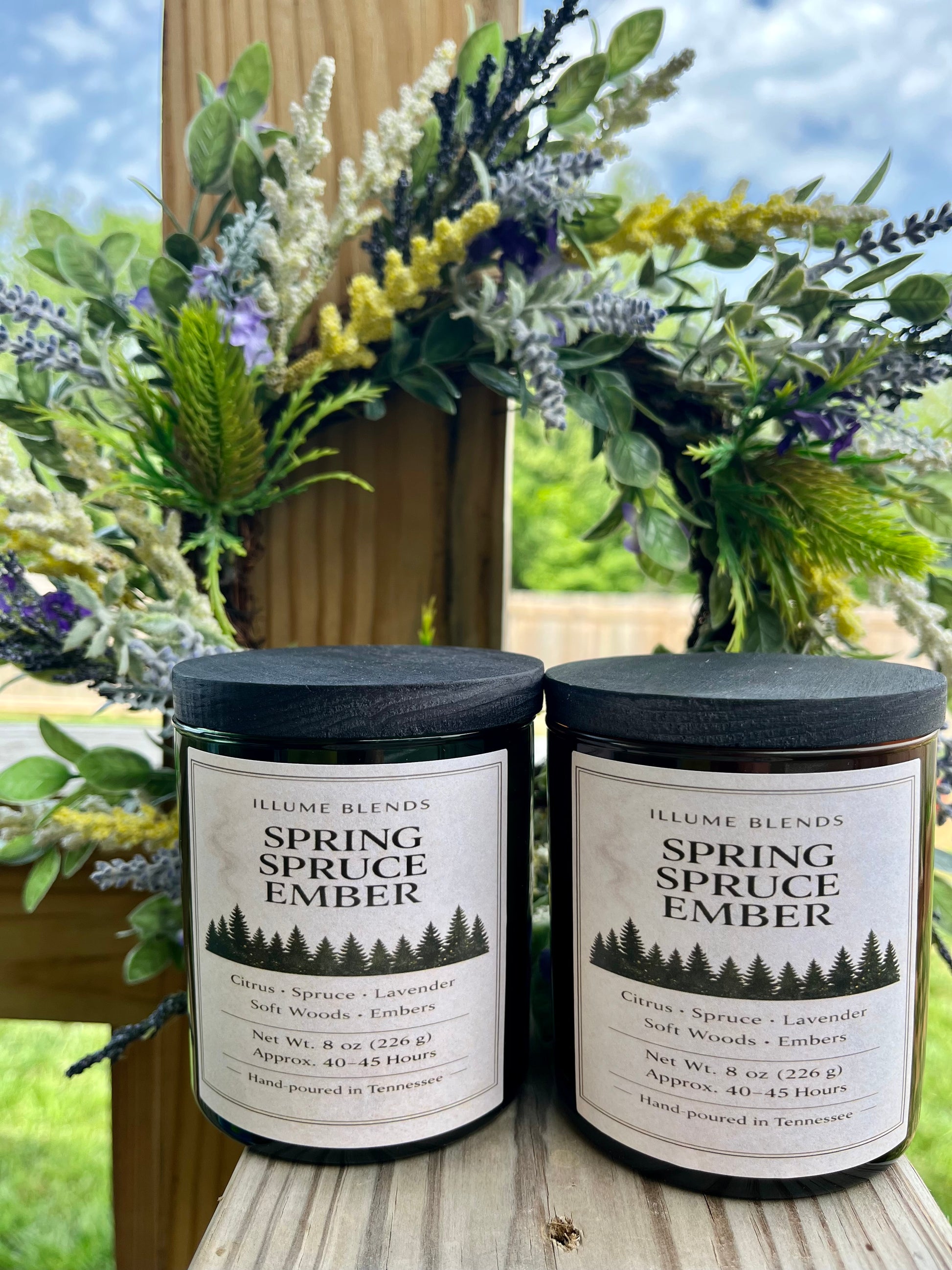 Two Spring Spruce Ember candles styled with greenery and spring florals.