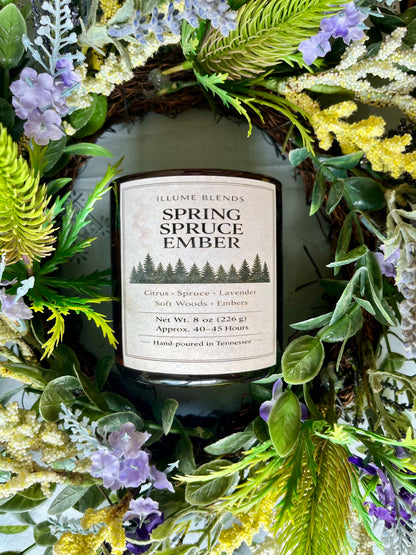 Spring Spruce Ember candle surrounded by fresh greenery and lavender accents.