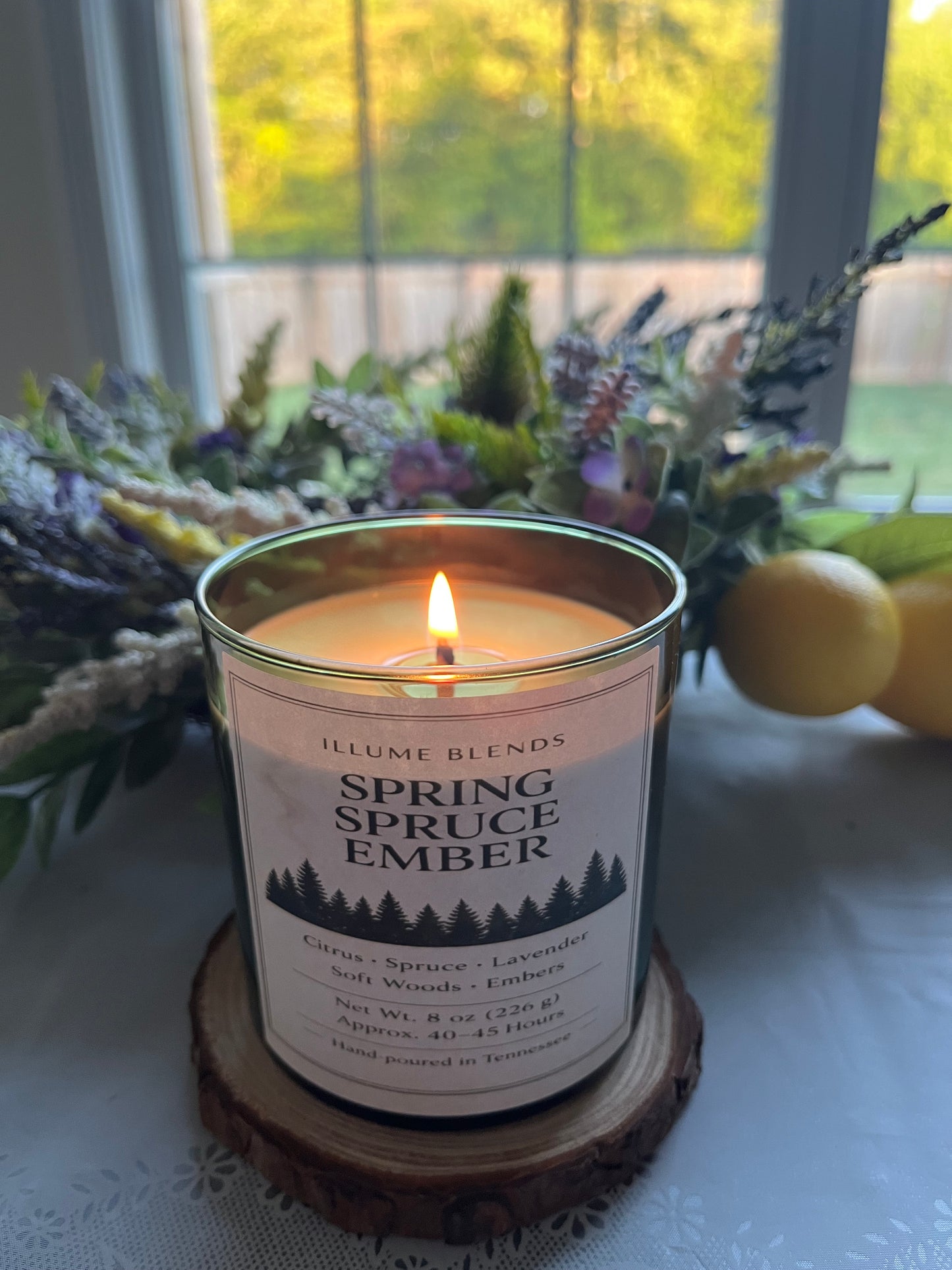 Lit Spring Spruce Ember candle with Tennessee-inspired woodland styling.